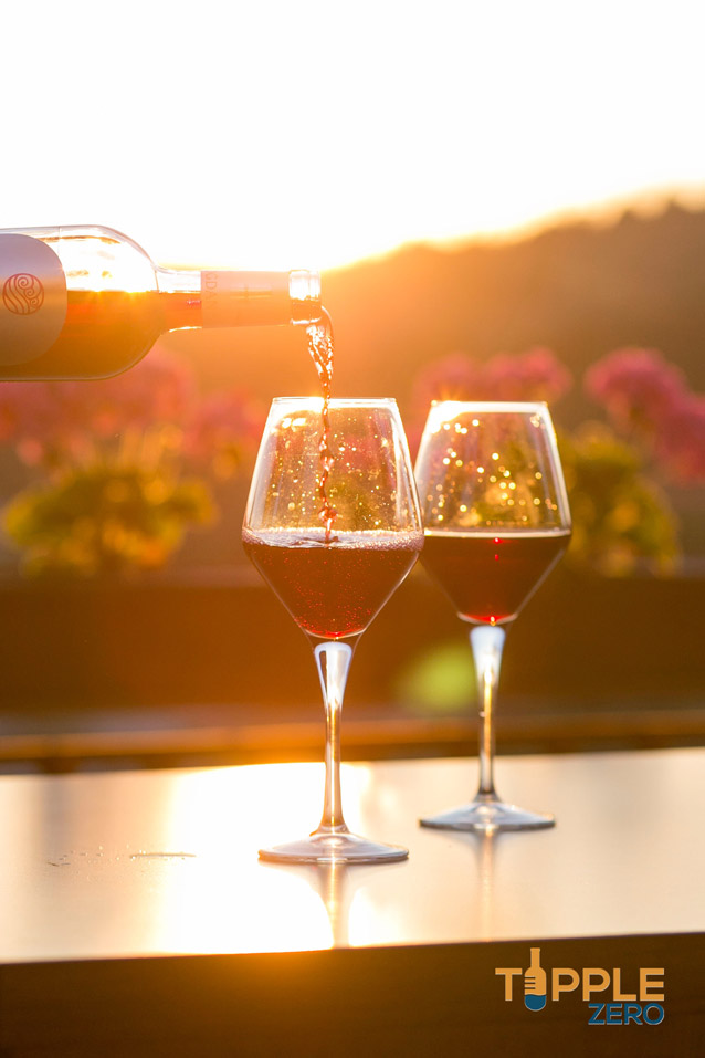 glasses of red on a balcony in the sunset